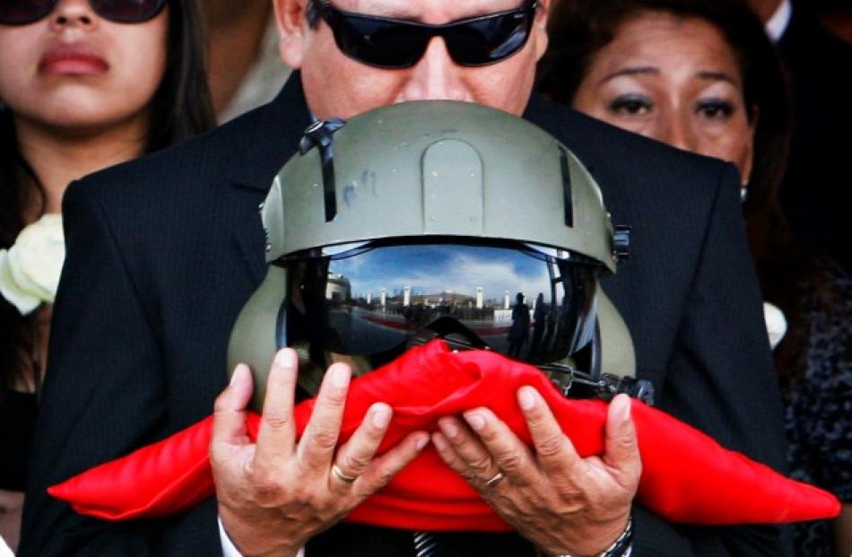 The father of Captain Nancy Flores kisses her pilot helmet during her funeral in Lima, Peru in...