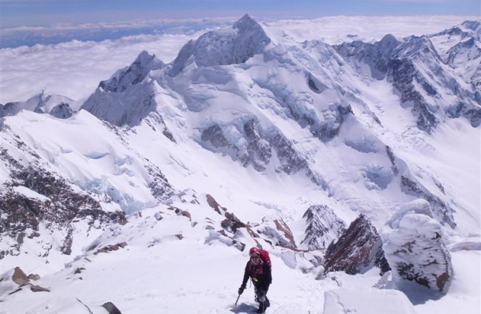 Philip Somerville emerges above the Summit Rocks on Aoraki Mt Cook.  The dominant peak behind is...