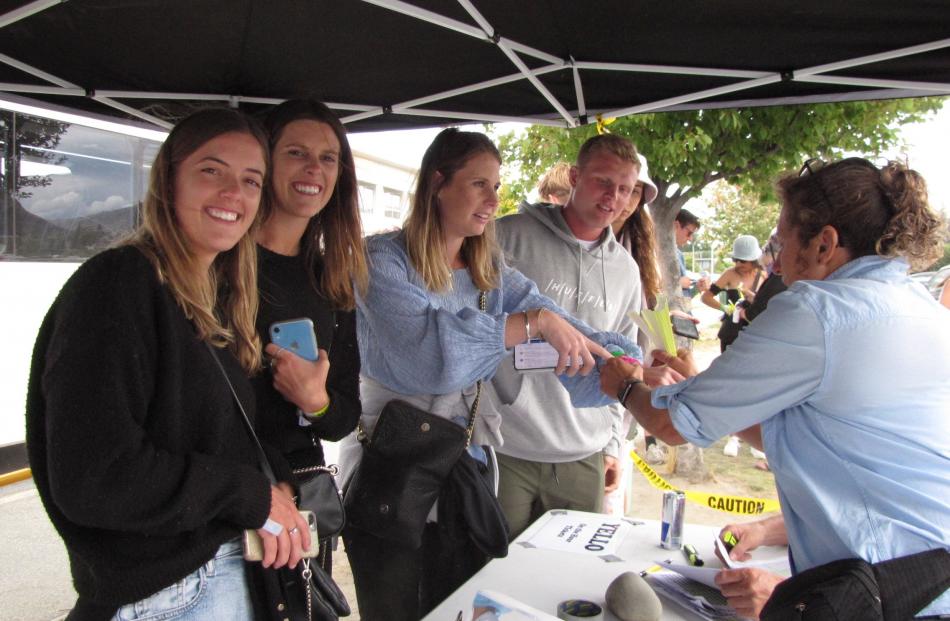 Wanaka volunteer Jenny Howe (right) assists Rhythm & Alps patrons with bus tickets from Wanaka. From left, Stephanie Masson, Lucy Kirk-Smith, Hannah Ostick and Tom Hardy, all from Auckland and aged 25. PHOTO: MARJORIE COOK