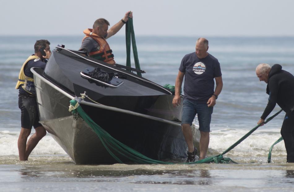 A salvage party works on the boat after its retrieval.