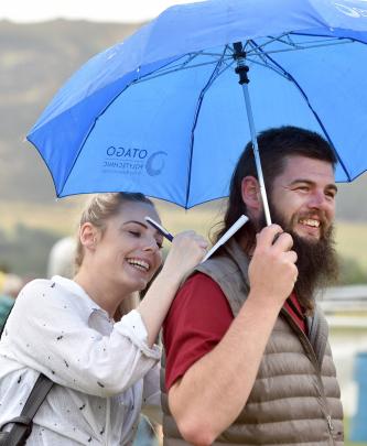Keeping out of the light rain are Georgina McCullough and Joel McCann, both of Dunedin.