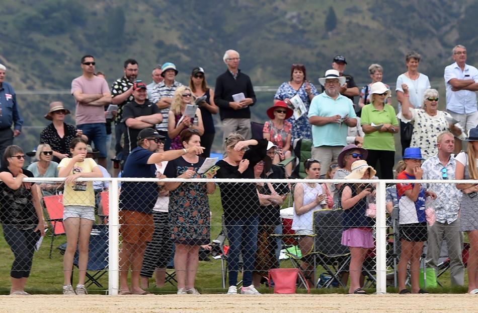 Racegoers line the track to cheer on their favoured runners.