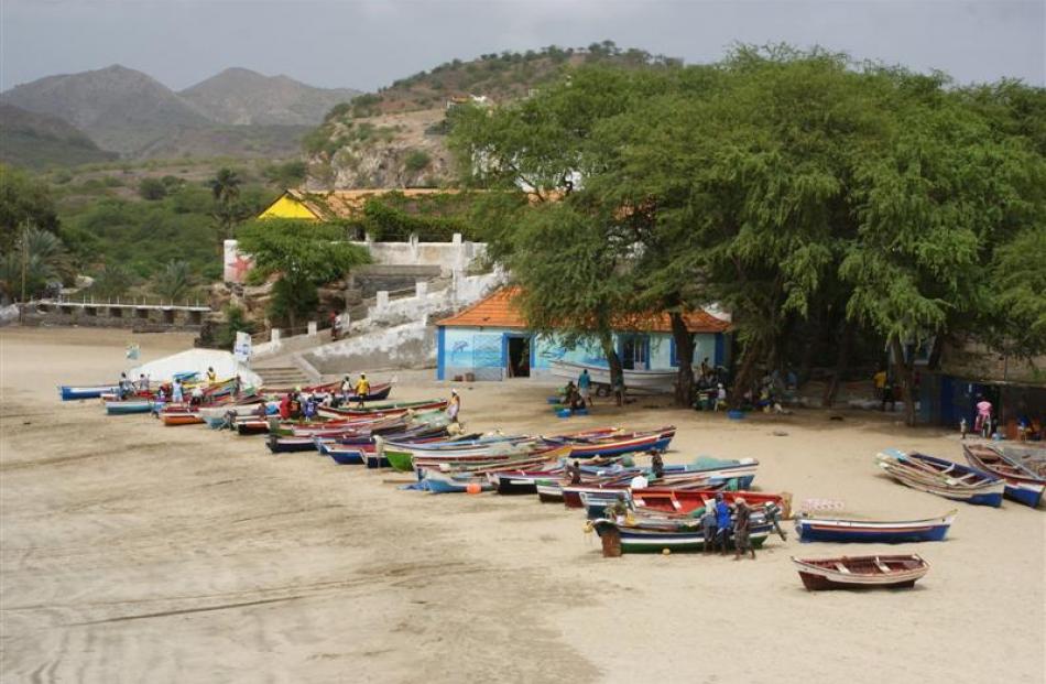 Colourful fishing boats line the white sand.