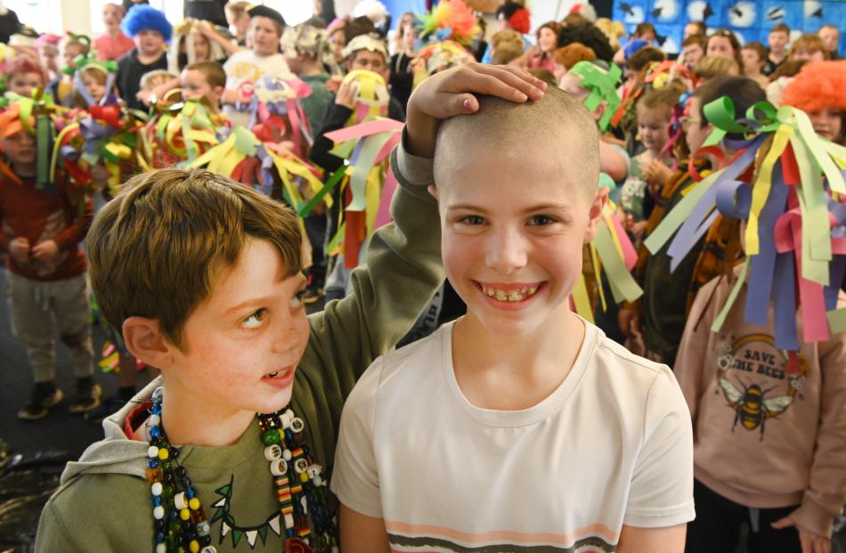 Freddie Dick (8) admires his sister, Olivia's (9), newly shaved head during a special Sawyers Bay...