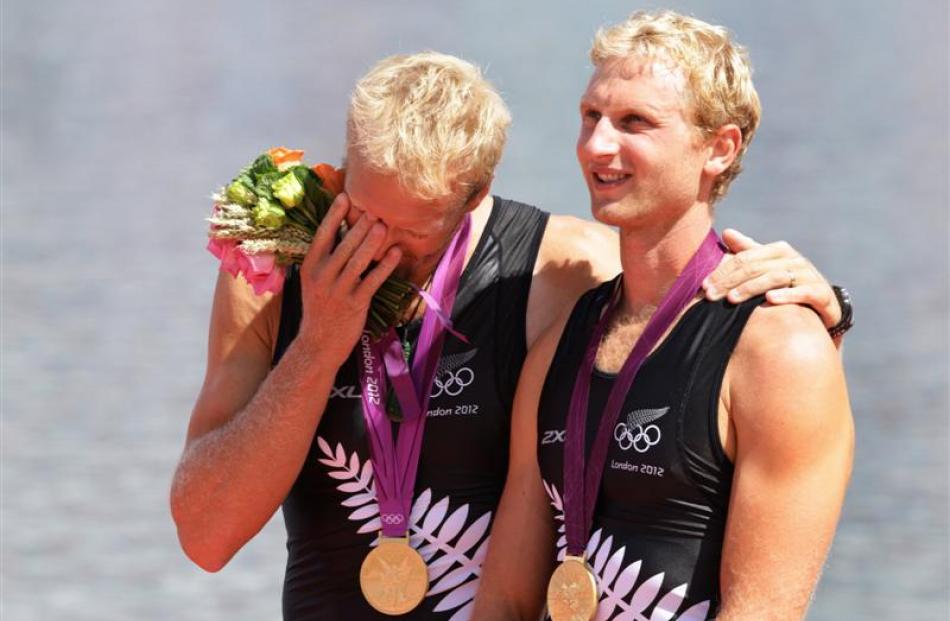 Hamish Bond (right) and his rowing partner, Eric Murray, stand on the podium after winning gold...