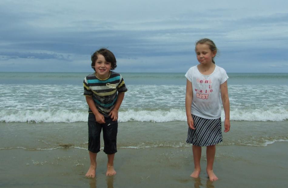 Levi Brown (5) and Marinah Brown-Butland (7), of Milton, enjoy a paddle at the beach on Monday.