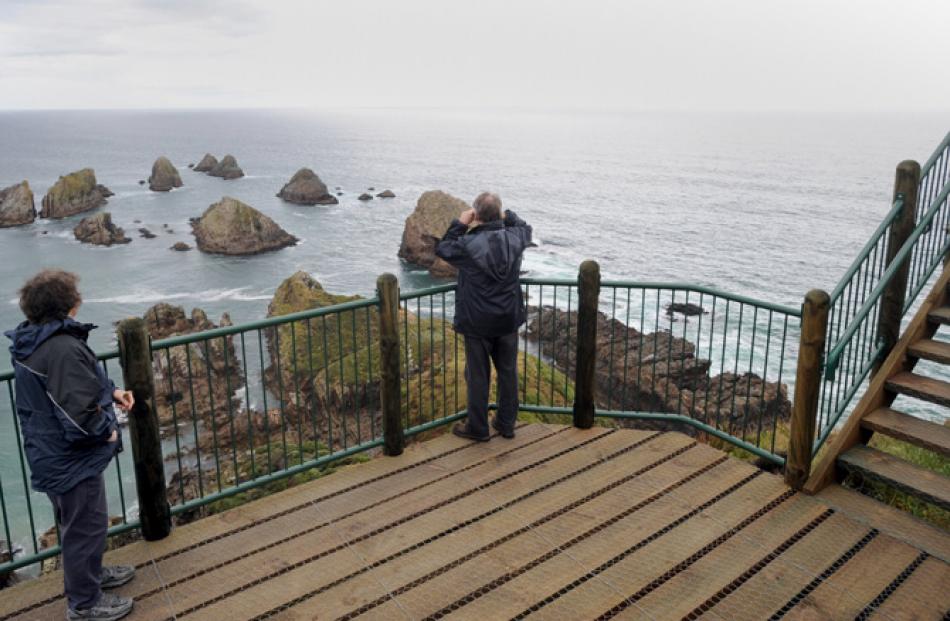 Visitors view  the Nuggets from the Nugget Point lighthouse viewing  platform.