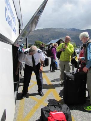Newmans driver John Hamilton loads and unloads bags at Wanaka after driving a full bus of...