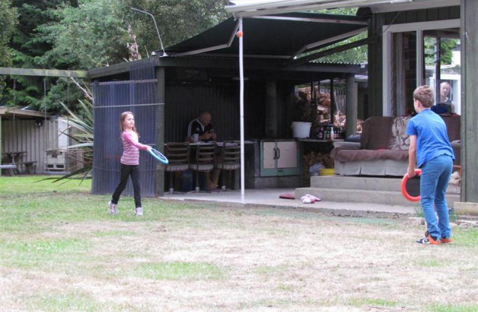 Sarah Jamison (7) and Hunter Jamison (9) enjoy a spot of back-yard tennis.