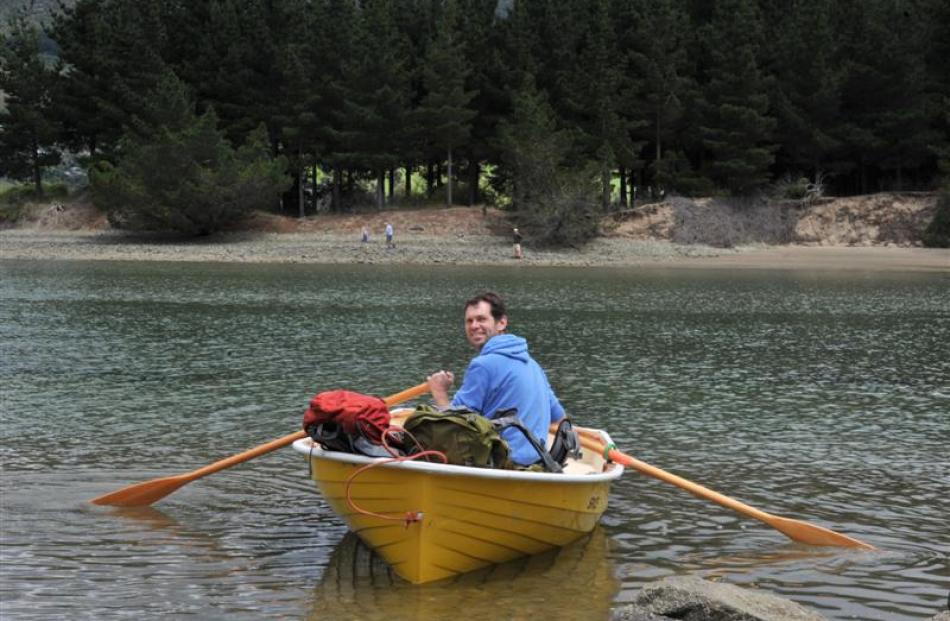 Dunedin resident Nigel Barrett rows the weighted packs of his parents Rodger and Judith Barrett...