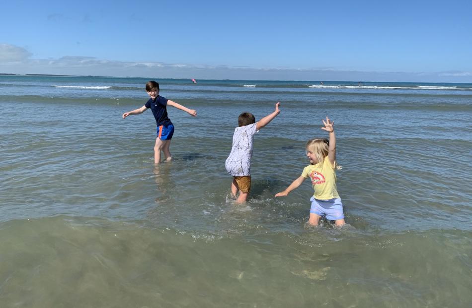 Siblings (from left) Bowie (9), Frankie (6) and Joey (3) Gallop enjoy a paddle in Taramea Bay,...