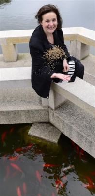 Garden manager Margo Reid feeds  fish at the Dunedin Chinese Garden. Photo by Peter McIntosh.