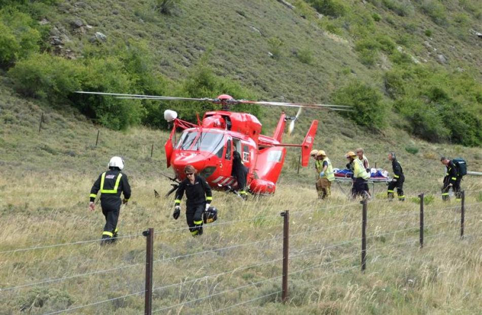 A seriously injured tourist is taken to the helicopter before being airlifted to Dunedin.