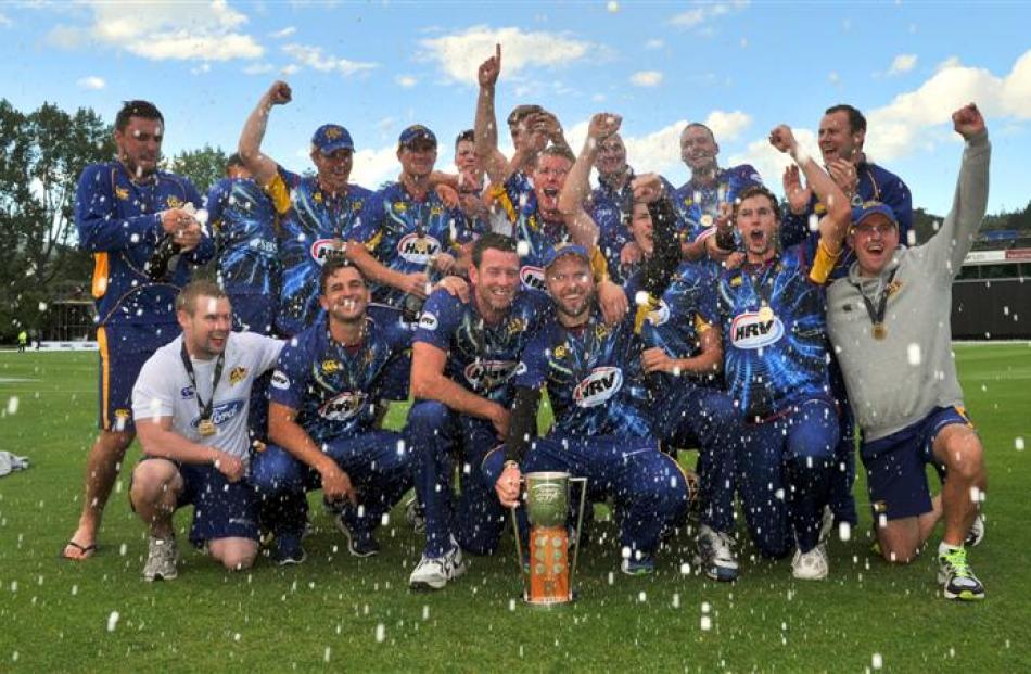 Bubbly flows as  Otago players and officials celebrate the team's four-wicket win over Wellington...