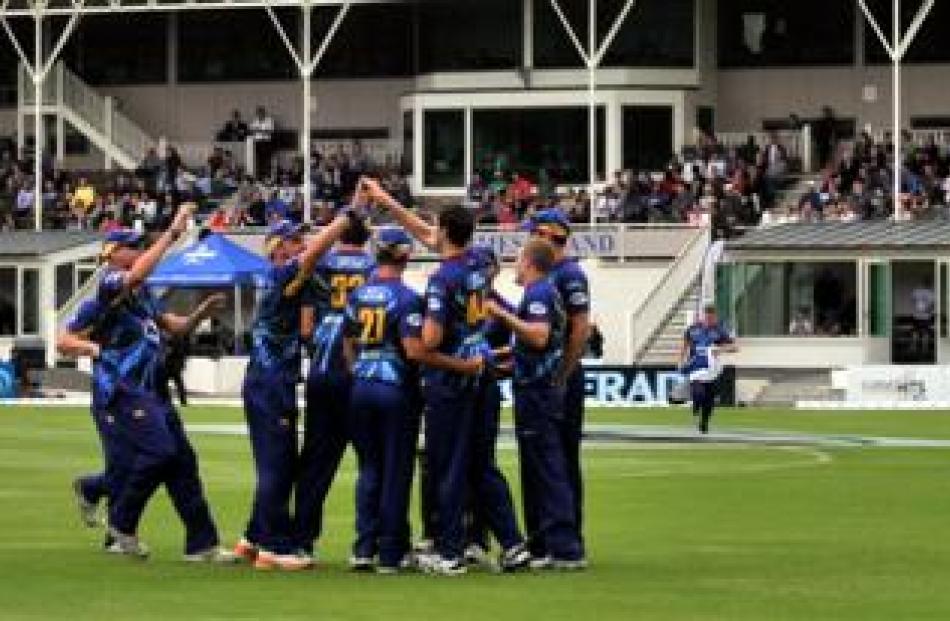 Otago Volts players celebrate the wicket of Wellington Firebird Luke Ronchi, caught by James...