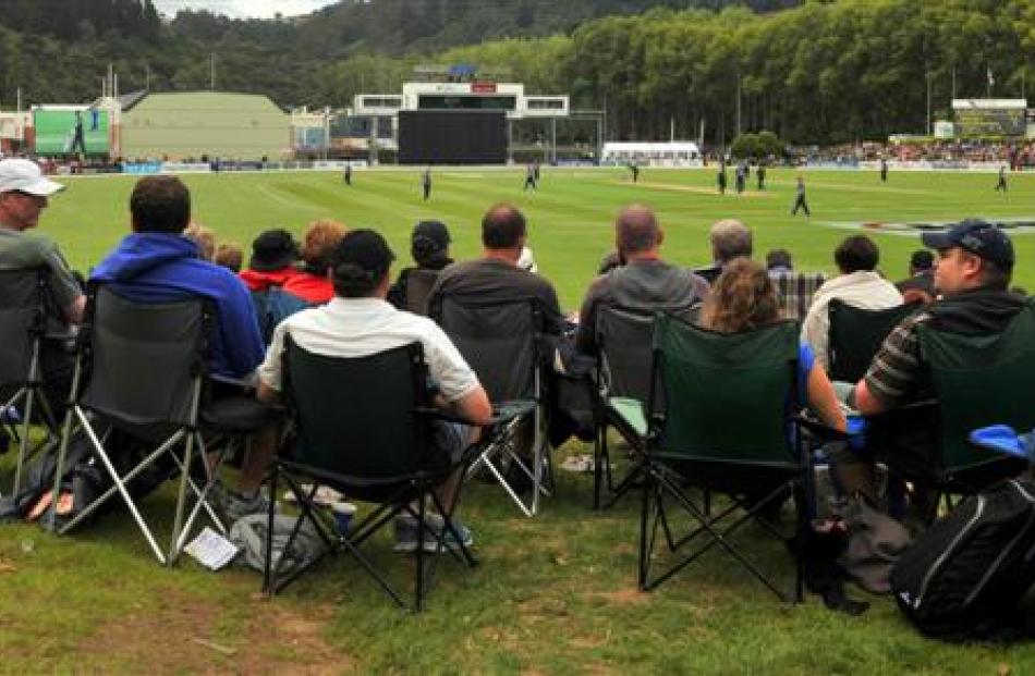 Spectators vie for space on a grass bank.