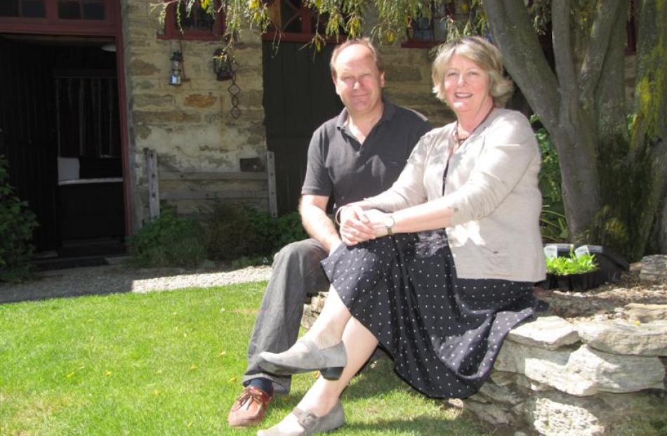 David and Andrea Ritchie sit among the restored buildings of Oliver's Lodge and Stables, formerly...