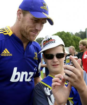Highlander Brad Thorn and Sebastian Ruehorn (12) of Oamaru look at an  iPod.