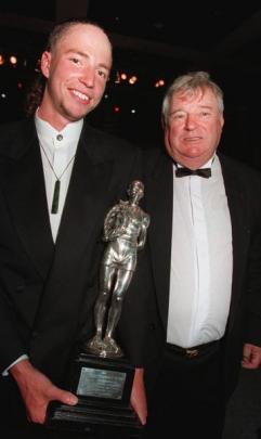 Olympic double gold medallist swimmer Danyon Loader holds his 1997 Halberg award next to coach...