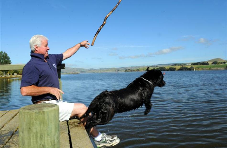 Lake Waihola Cafe & Bar owner Kevin Reid plays  with his dog Tess despite the warning signs about...