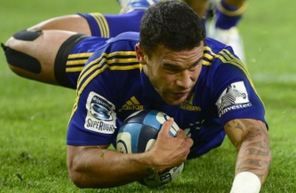 Highlanders winger Kade Poki skids over the line to score a try during his team's Super 15 match...