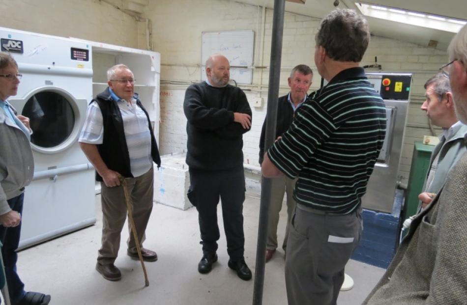 A tour group is shown around the Dunedin Prison laundry.