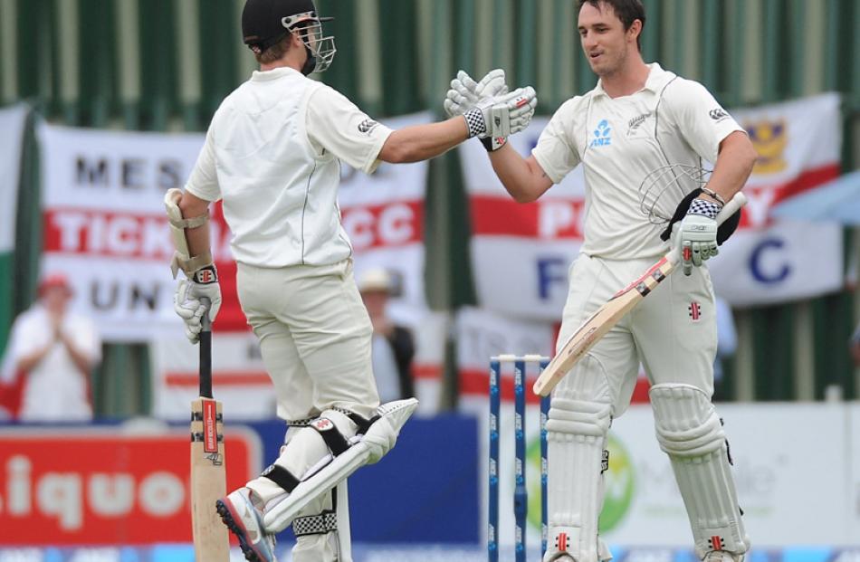 Williamson shakes hands with Rutherford as Rutherford celebrates his century on day 3.