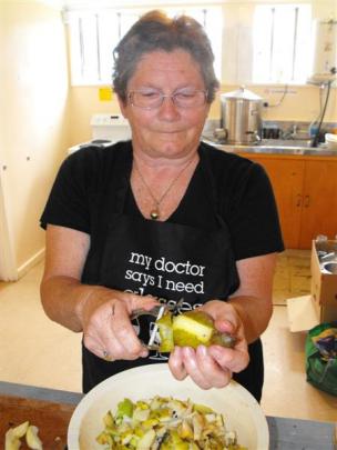 Pat Hanan, of Northeast Valley, peels the donated pear in preparation for making a pear, date and...
