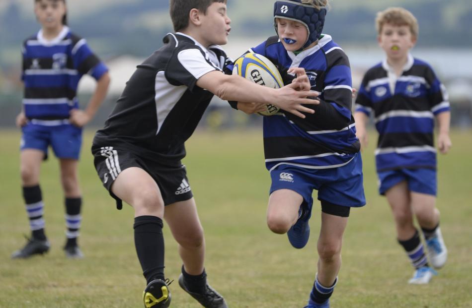 Henry Prately (10, right), from Kaikorai Black, fights off a tackle from Isaiah Sarkies (9), of...