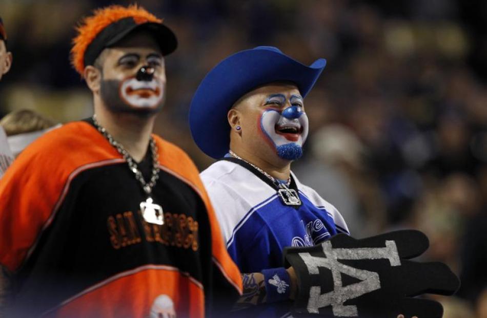 A San Francisco Giants fan (left) and his Los Angeles Dodgers equivalent watch their teams do...