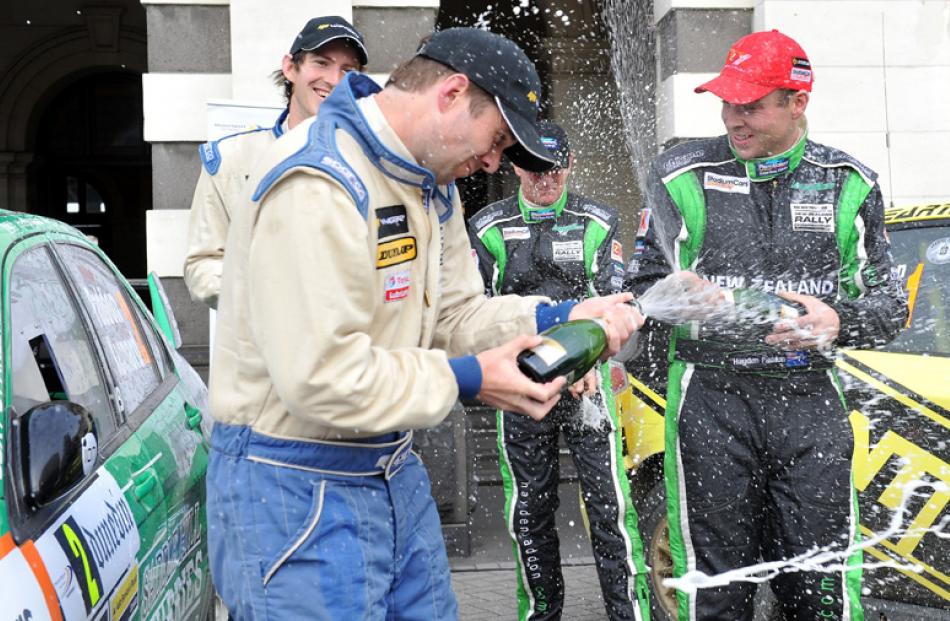 Tony Rawstorn, left, sprays Rally of Otago winner Hayden Paddon with champagne as Ben Hunt and...