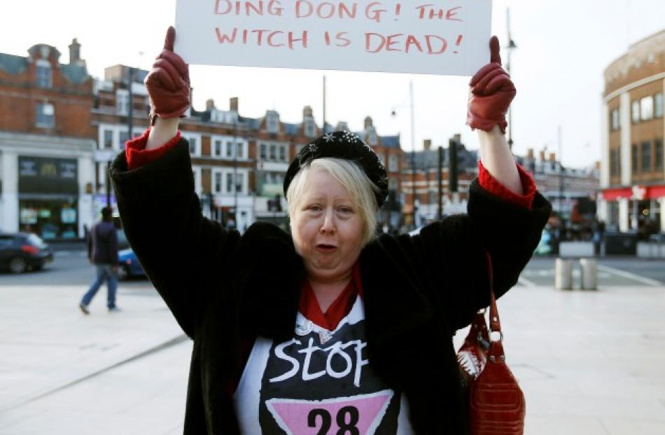 A woman holds up a sign that shows her reaction to Thatcher's death. REUTERS/Olivia Harris