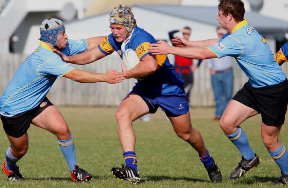 Taieri openside flanker Willis Scott fends off University hooker Sam Sturgess.