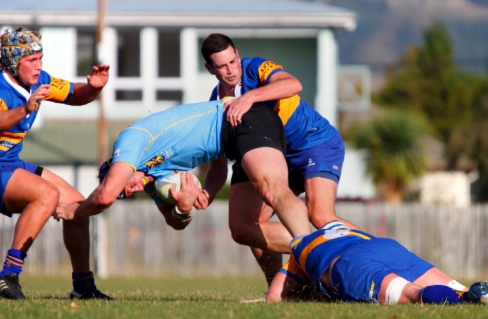 University No 8 Paul Grant is tackled by Charlie O'Connnell, Will McKee and Willis Scott.