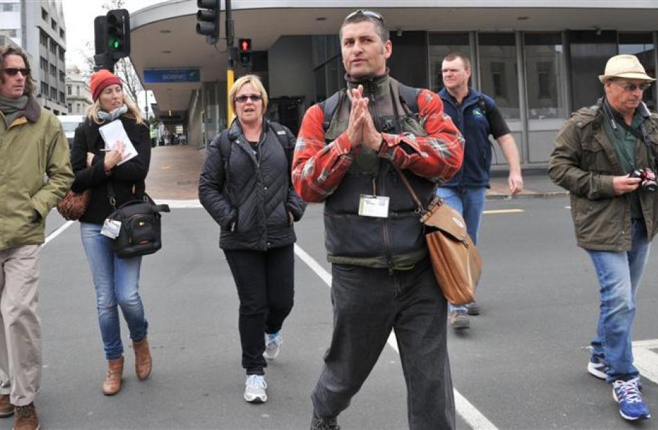 A group of Australian visitors follows Mr Parks across Dowling St on the southern slopes of Bell...