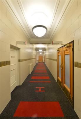 A Dunedin Town Hall gallery passage resplendent in cream, greys and red.