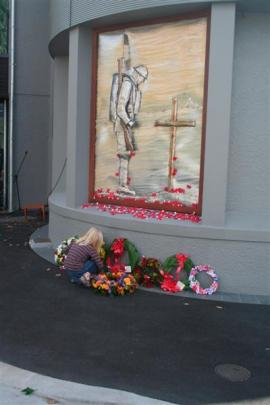 A Queenstown girl lays a poppy among the wreaths at the Queenstown Memorial Centre yesterday.