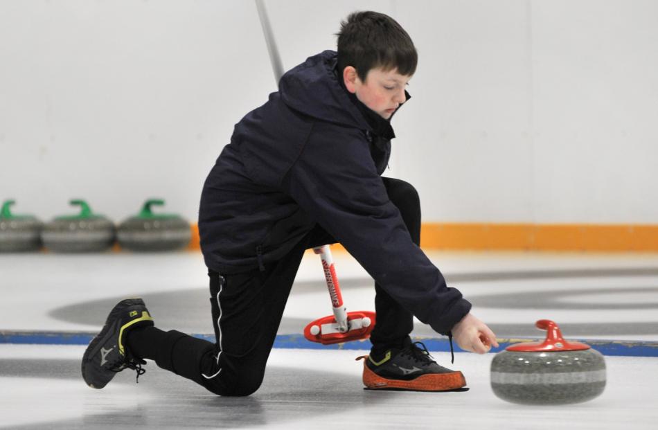 Kavanagh College’s Isaac McIlvanney lets go of his stone during the curling at the Dunedin Ice...