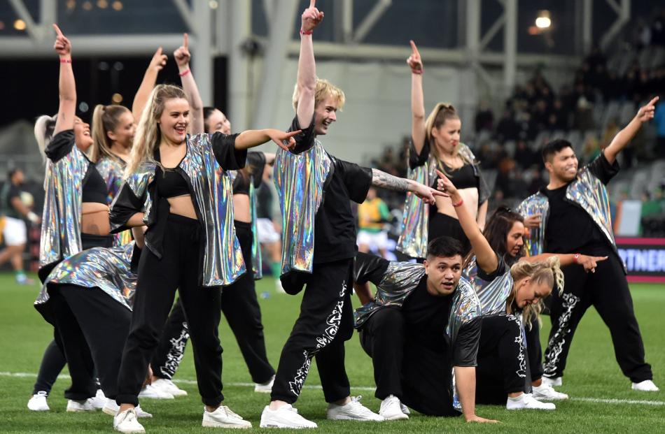 Dancers excite the crowd from the pitch.