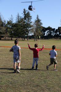 Fernside School pupils guide the Robinson R44 helicopter in to land. PHOTO: JOHN COSGROVE