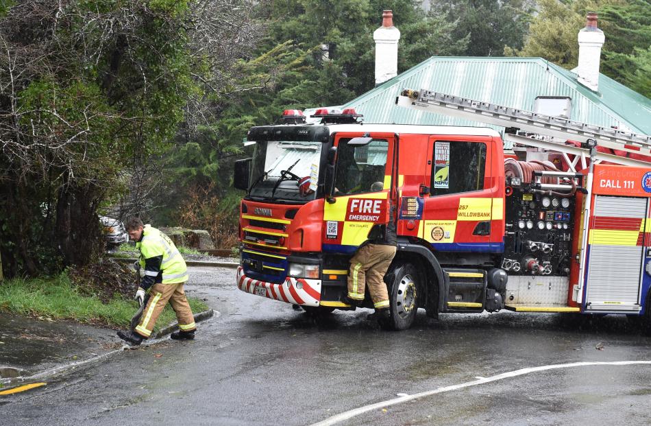 FENZ staff clear the gutter in Buccleugh St on Tuesday. PHOTO: GREGOR RICHARDSON