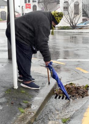 Neville Tressler clears leaves from stormwater at the bottom of London St. PHOTO: STEPHEN JAQUIERY
