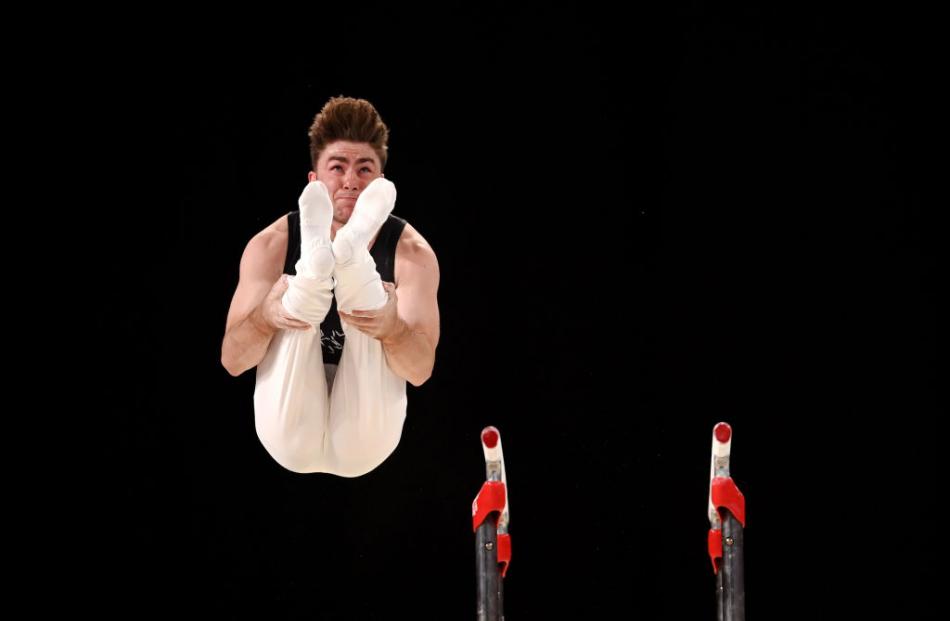 Ethan Dick competes on the parallel bars during the men’s all-around gymnastics final.