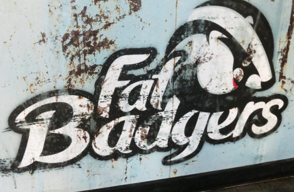 Singed . . . The burned logo of Fat Badger's Pizza at the entrance.