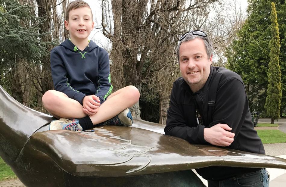 Nico Low (9) and his father Simon take a quick break on the bronze sculptures.