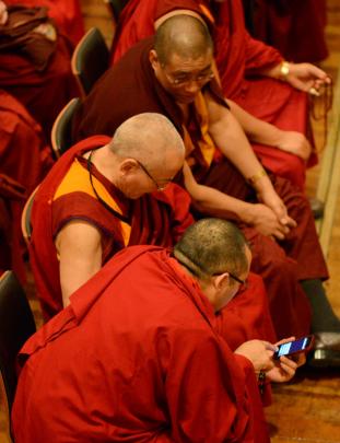 Buddhist monks with their cellephones before the Dalai Lama's speech in the Dunedin Town Hall.