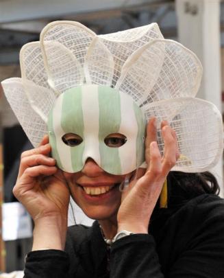 Midwinter Carnival artistic director Julie Novena Sorrel tries on a mask at a Midwinter Carnival...