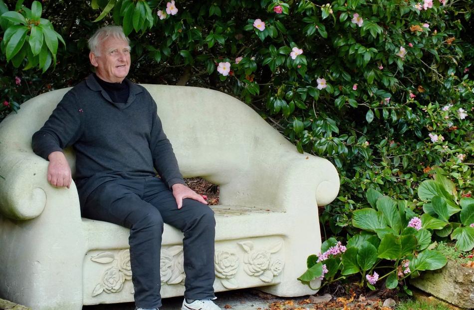 Broadfield Garden owner David Hobbs on a seat carved from a seven-tonne block of Oamaru stone.