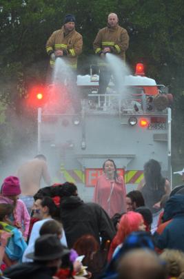 Firefighters Blair Harcus (left) and Robin Hulsbosch spray Polar Plunge swimmers with warm water...