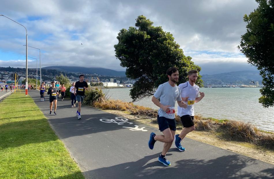 Half marathon competitors Joel Tebbs (25) and Louis Martin (882) make their way alongside the...